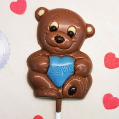 Sucette ourson coeur bleu dans les bras au chocolat au lait